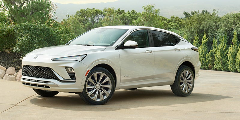 white 2024 Buick Envista sitting in a driveway in front of some trees
