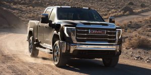 black 2025 gmc sierra HD driving down a dirt road